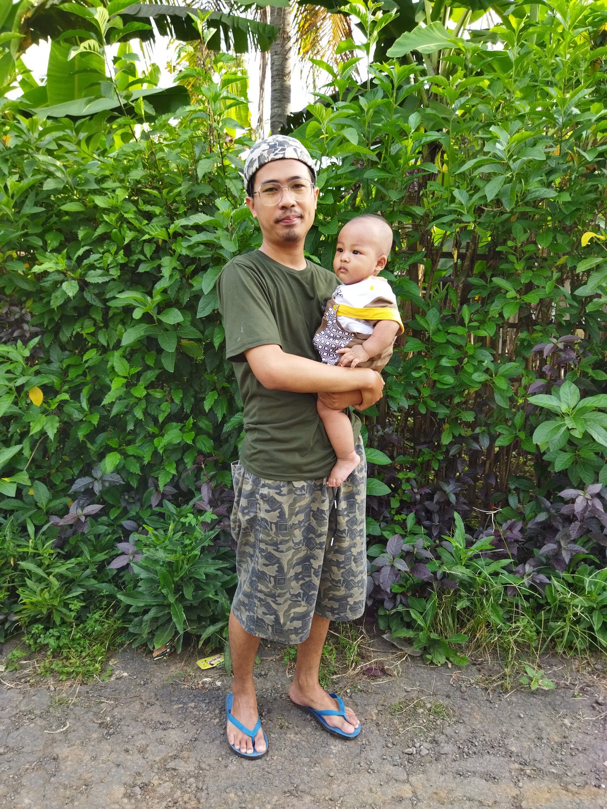 Zulhaj menggendong anak di kebun