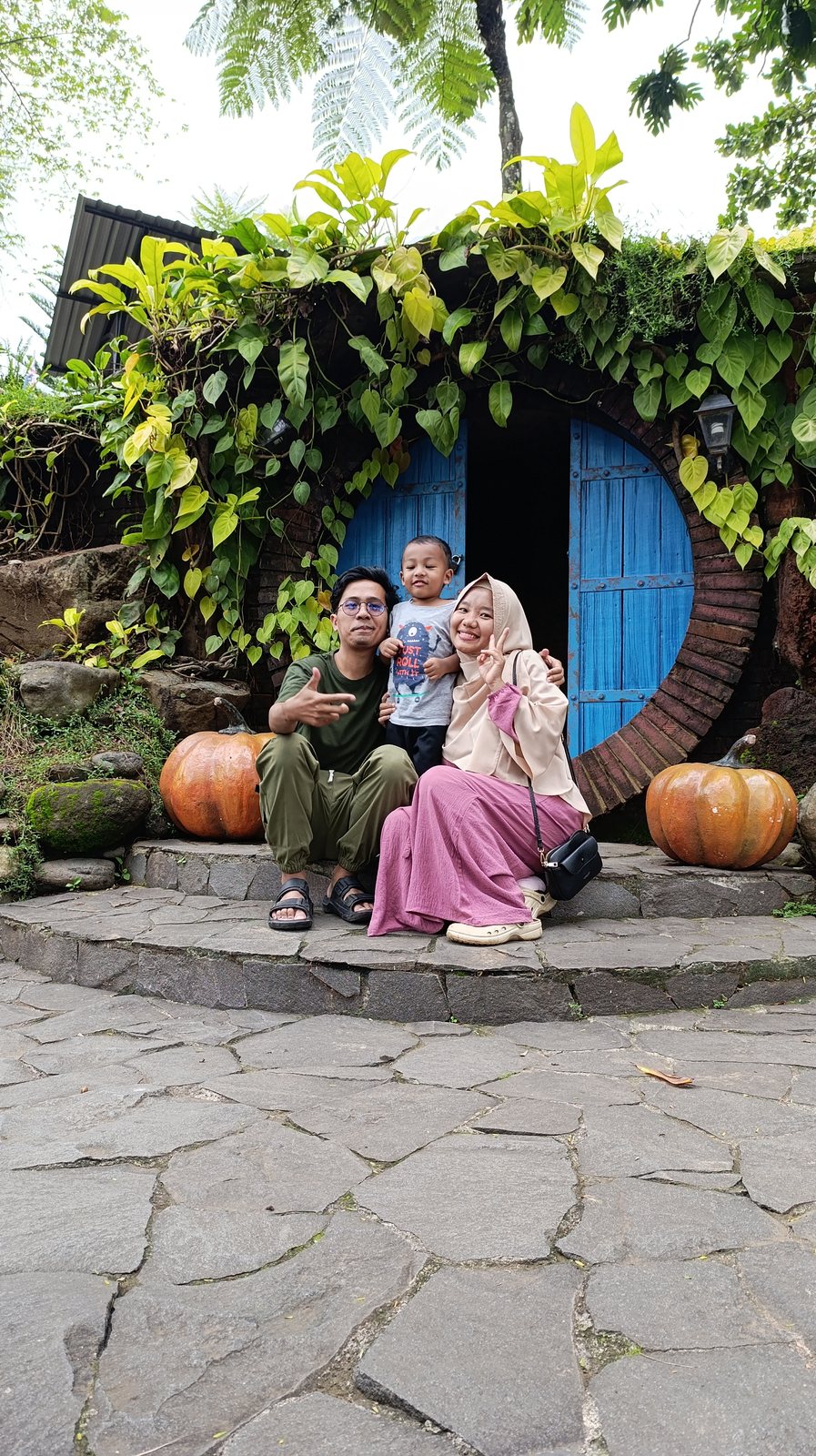 Keluarga berfoto di tempat wisata