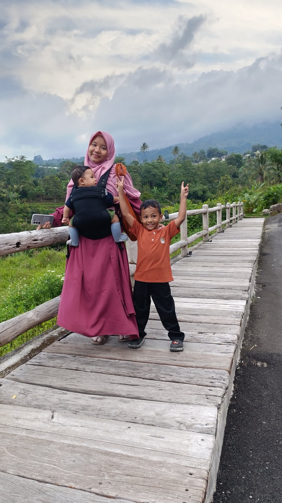 Febri dan anak berfoto di atas jembatan